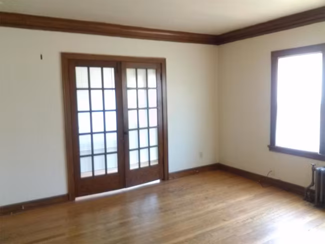 Empty room with wood floors and glass-panel doors